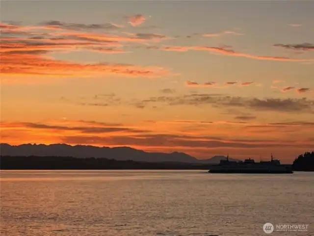 The sun dips low on the horizon, casting a warm golden glow across the water. The ferry gliding slowly across the water silhouetted against this amazing sunset is just one of the many sights you'll experience in your waterfront paradise.