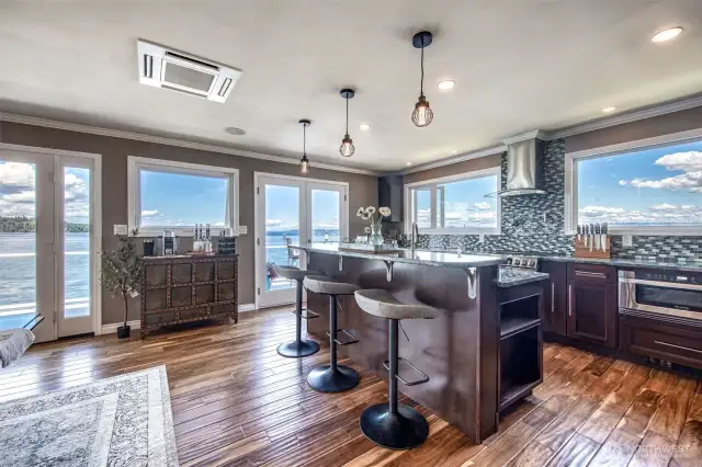 As you reach the top of the stairs you are greeted with phenominal views. The space opens up to the kitchen, dining area, and living room. With 3 sets of french doors that lead to a beautiful deck to take in those amazing views.
