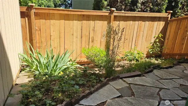 Side yard includes a small garden area—perfect for flowers, herbs, or seasonal veggies