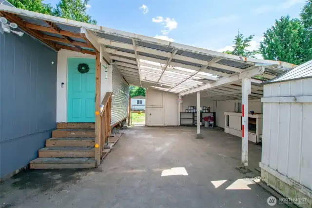 Large lean-to carport area with a little work bench.  Gate access to backyard