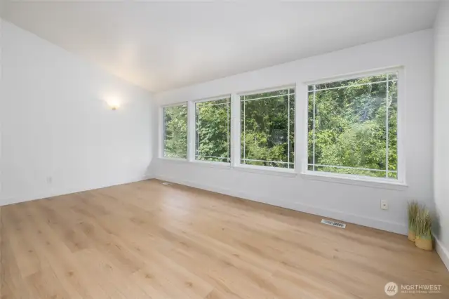 Large windows provide natural light and views of the green space.