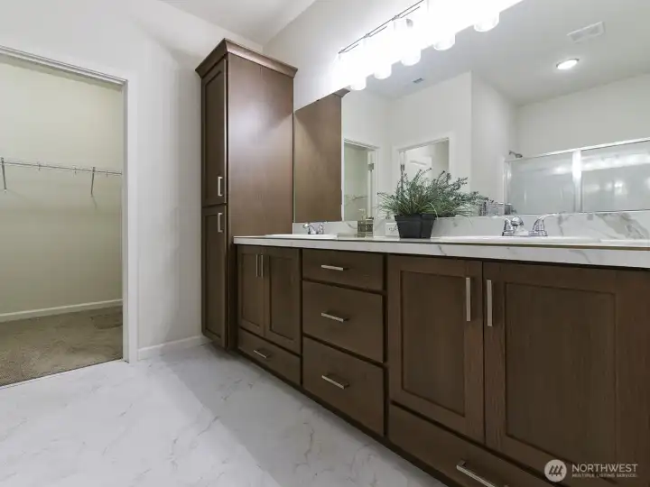 Primary bath has two sinks and granite countertops. Deep pull out drawers and extra tall cabinet for all those extra needs.