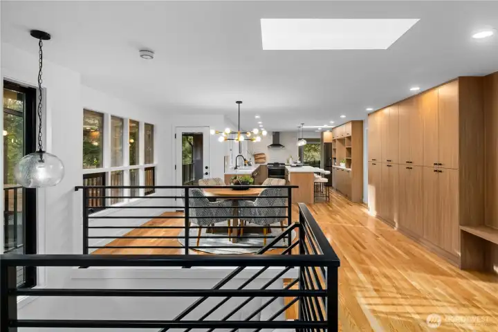 Dining area with skylight, custom aluminum railing, and direct access to the deck, offering an easy indoor-outdoor flow.