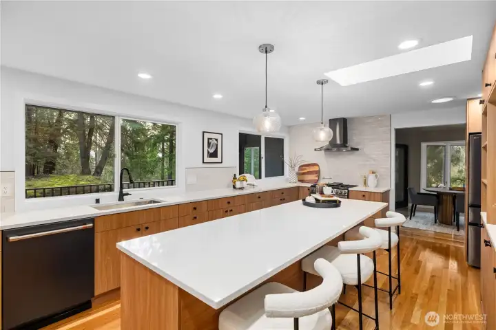 Oversized island with seating and updated lighting creates a functional gathering space for everyday use and entertaining.