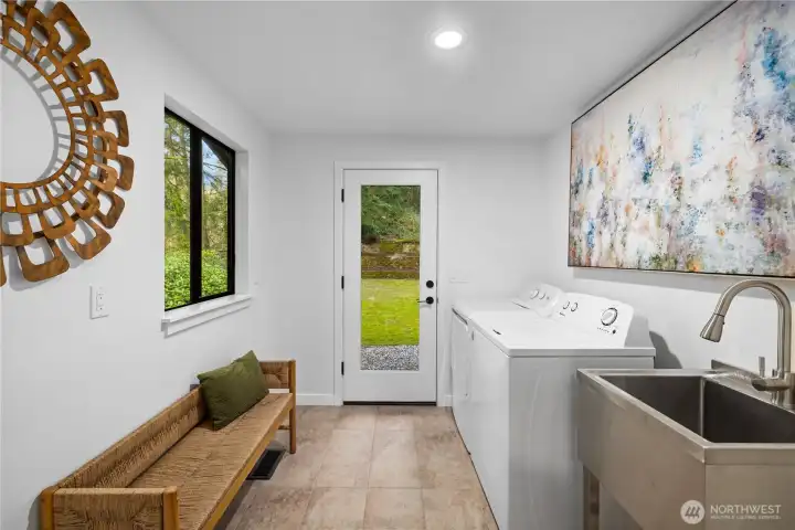 Updated laundry room with new tile flooring, utility sink, and exterior access—designed to handle real life with ease (muddy shoes and all).