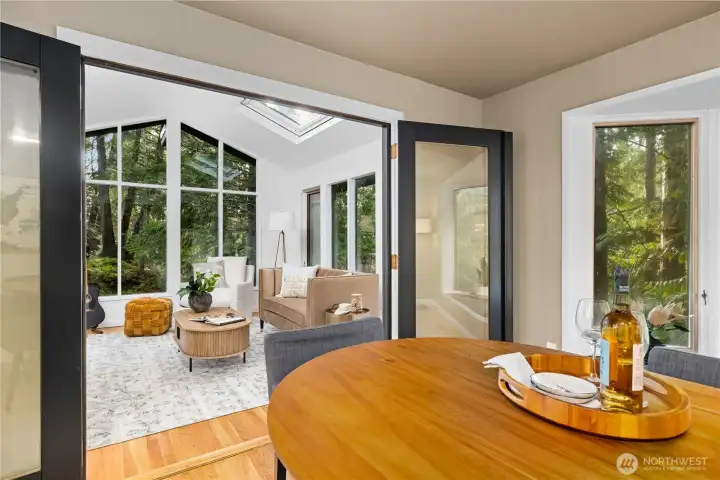 Dining area opens to a bright sunroom through updated doors, allowing for easy flow when entertaining or everyday living.