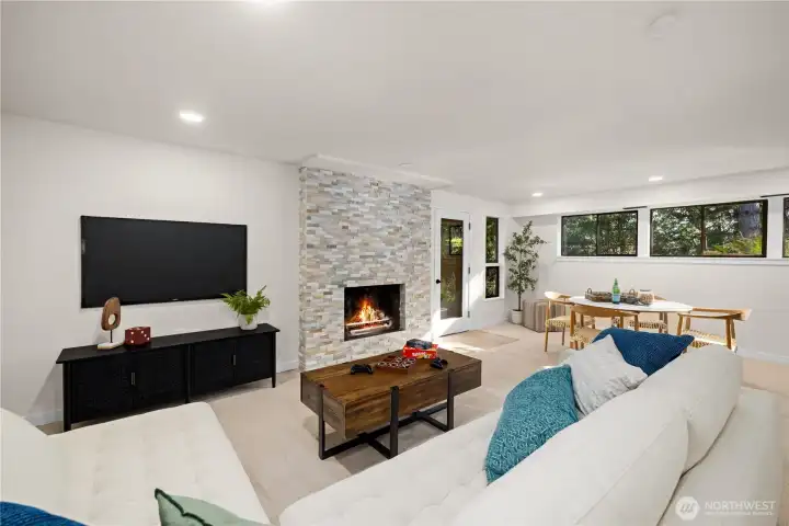 Expansive lower-level living area with refreshed fireplace, new finishes, and space for media, games, or relaxed gatherings.