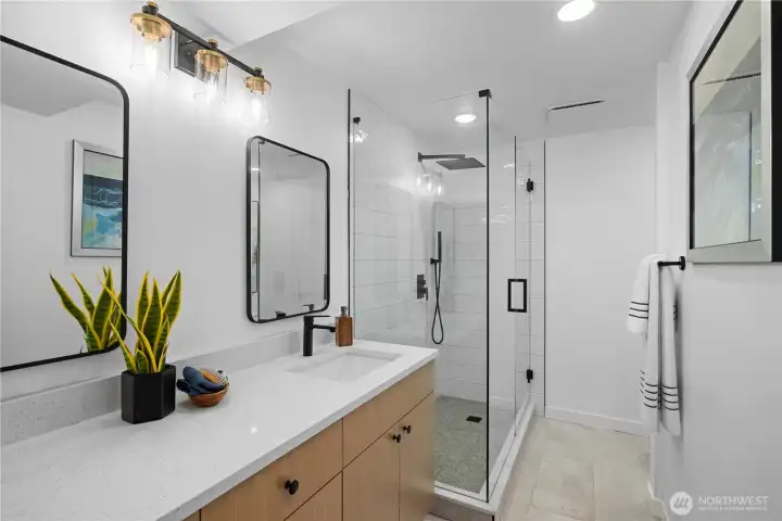 Remodeled bathroom with quartz countertops, walk-in shower, and modern fixtures reflecting the home’s comprehensive renovation.