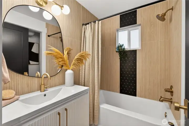 Modern full bathroom with updated fixtures and finishes reflects the comprehensive renovation quality found throughout this turnkey home.