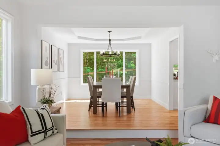 Refined dining room featuring a tray ceiling, chair-rail detailing, and modern designer finishes.