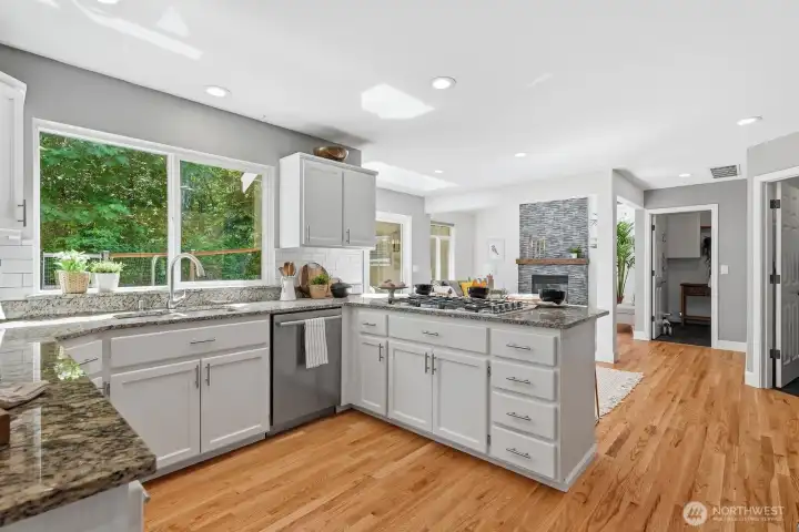 Beautifully remodeled kitchen with crisp white cabinetry, subway tile backsplash, and slab granite countertops.