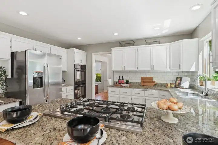 Stainless steel appliances include a gas cooktop and double oven.