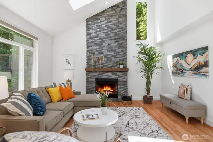 Vaulted family room with skylights and a dramatic floor-to-ceiling stone fireplace creates the perfect gathering space.