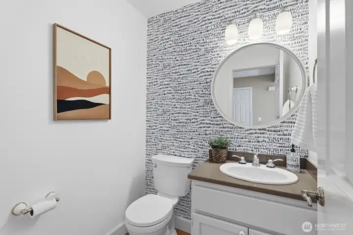 Chic main-floor powder room featuring eye-catching designer wallpaper, quartz counters, and updated fixtures throughout.