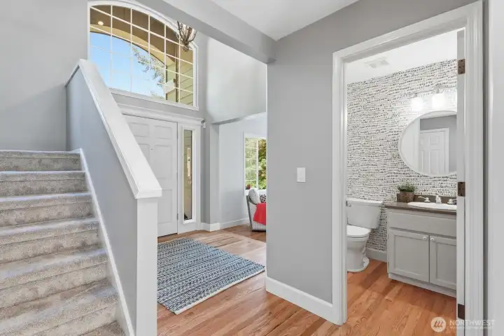 Centrally located designer powder room and staircase lead to the upper level featuring four bedrooms and two full baths.