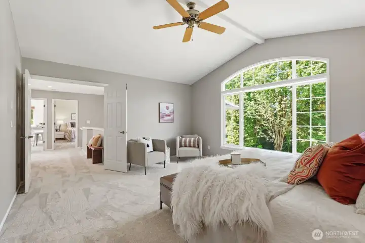 Spacious primary retreat featuring soaring vaulted ceilings, a walk-in closet, and a private ensuite bath.