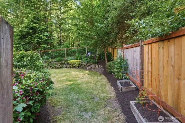 Spacious fully fenced backyard offers room for gardening, recreation, and entertaining.