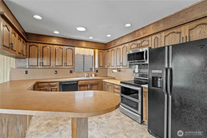 Kitchen w Stainless and Black Appliances, Easy-Car Laminate Flooring and Custom-Built Real Hardwood Cabinets. A few update here, like Quartz counters & flooring, could easily update this space!