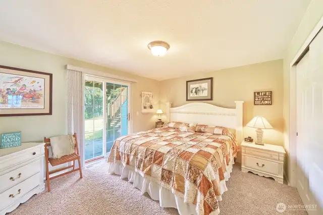 Large downstairs bedroom with slider to back patio looking out at the canal.