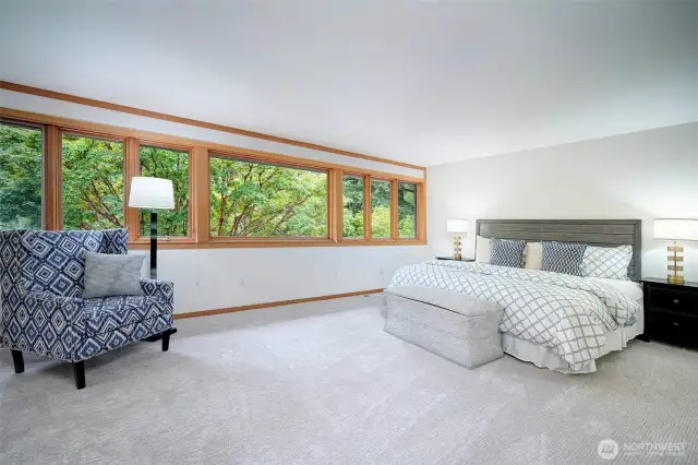Primary Bedroom with wall of windows toward backyard landscape with specimen trees.