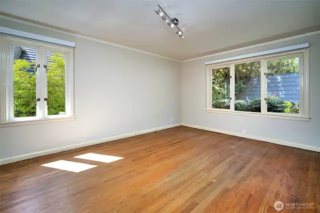 One of two main floor bedrooms, with wood framed & double paned window for natural light and refreshing breezes.