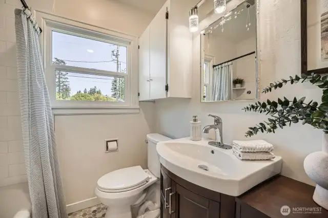 Full bath on main floor includes an oversized tub, new vanity with LED lighting, and an intricate hexagonal floor pattern!