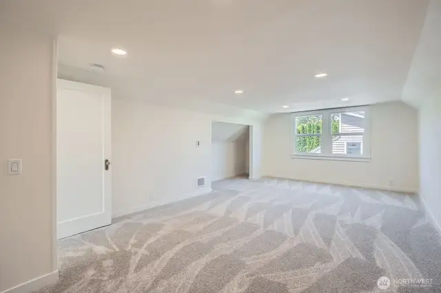 Upstairs bedroom offers plenty of space with a walk in closet behind from this photo, and new paint, deluxe carpet, and LED lighting.