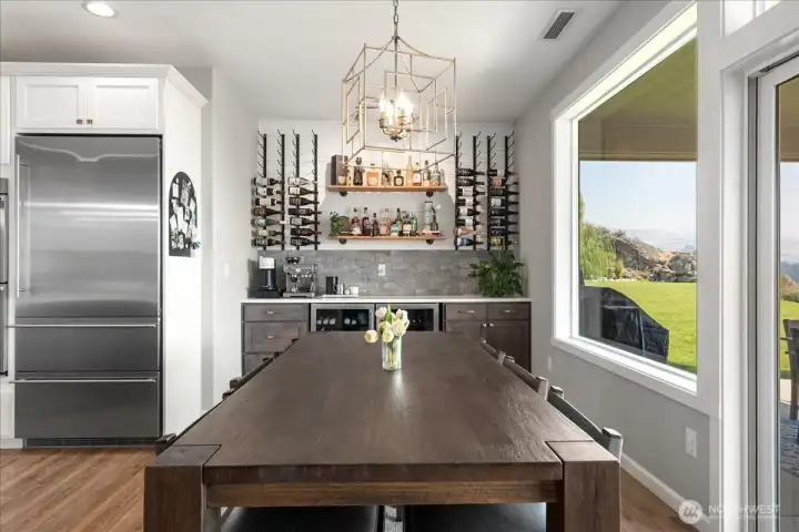 View of dining table with built-in bar with 2 beverage fridges.