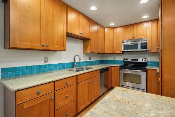 Custom kitchen with eco-friendly Thai Rubber Wood cabinets, granite countertops, ceramic knobs by local artist and stainless appliances.