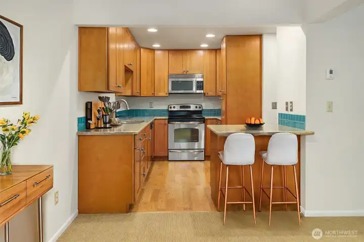 Virtually staged kitchen with stools at breakfast bar.