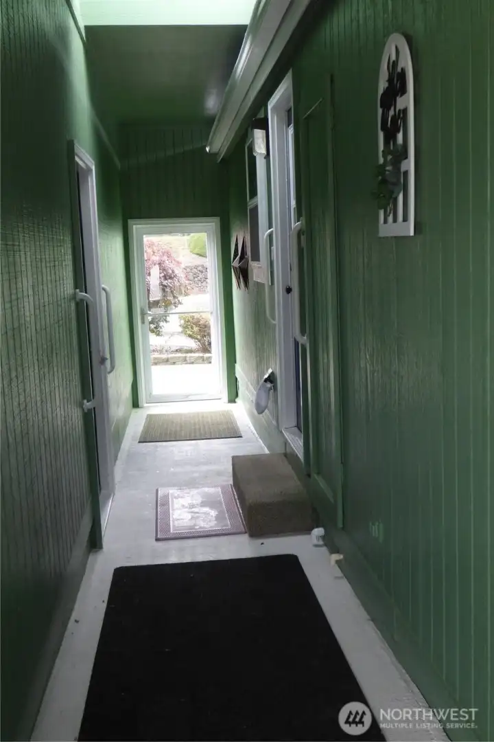 Covered breezeway to the garage and driveway. Notice the door at the end for wind and weather protection. The other end leads to the covered patio.