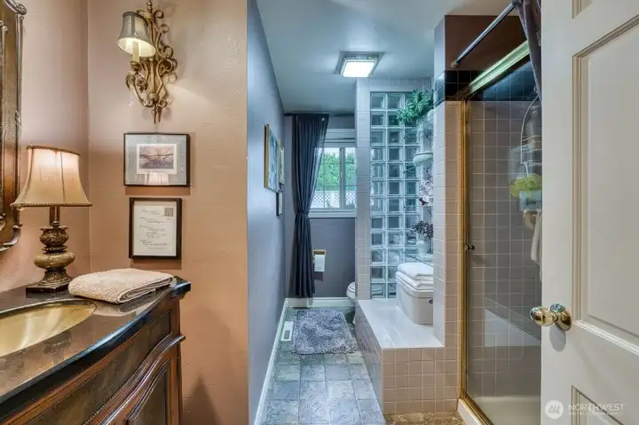 The beautiful guest bath with a large shower and classy touches.