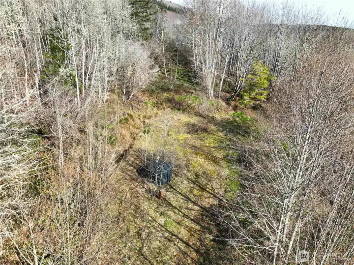 Upland, West acrage top of hill. 40 gpm wellhead with holding tank.