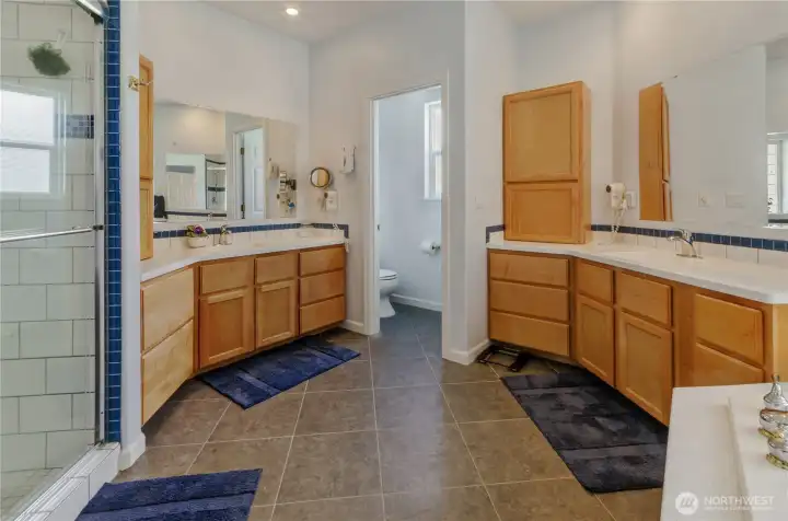 Water closet, separate vanities, tiled shower stall, and all the elbow room you could ask for in between