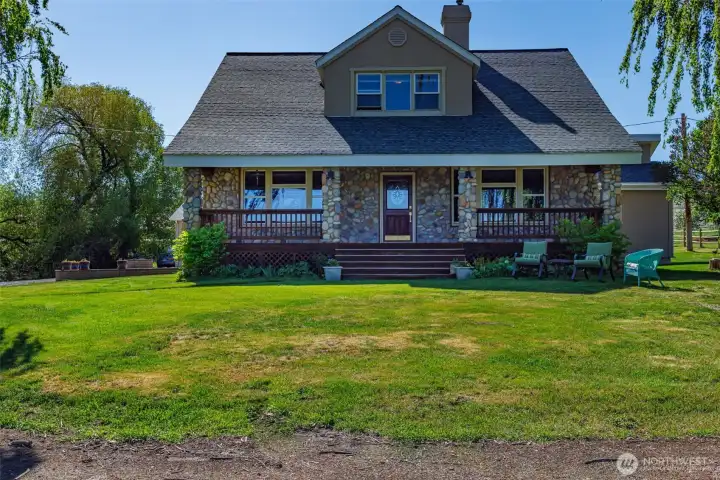 This photo showcases the main house, built in 1915. Covered porch and beautiful river rock facia that adds to its rustic charm. This home offers both comfort and tranquility in a stunning countryside setting.