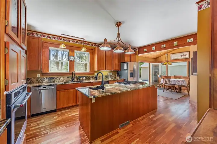 This photo highlights the beautifully updated kitchen, featuring new floors, granite countertops, and custom cabinetry. A perfect blend of style and function, making this space ideal for both everyday living and entertaining.