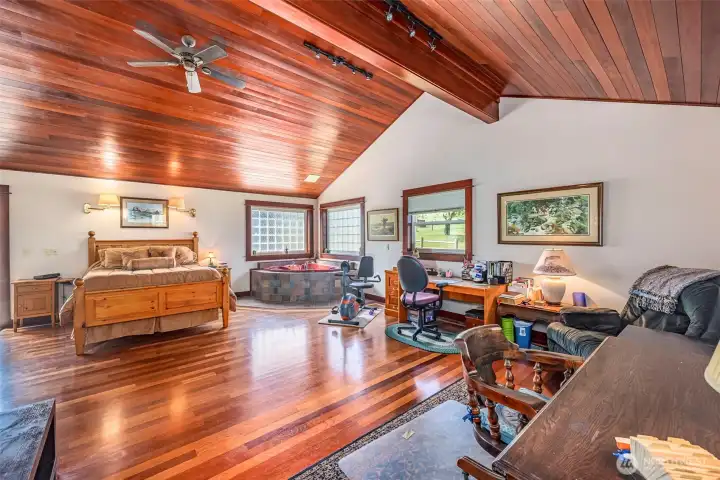 This spacious primary suite includes a large jetted tub, a cozy sitting area perfect for an office or exercise space, and a walk-in closet with built-in organizers. The room is highlighted by Brazilian Cherrywood floors, adding warmth and elegance to this luxurious retreat....