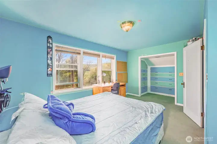 This spacious second bedroom upstairs offers a large walk-in closets and built-in drawers, providing plenty of storage space. A comfortable and organized room.