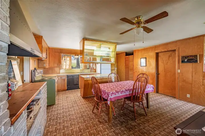 This charming kitchen area features a convenient eating space, perfect for casual meals or enjoying morning coffee. The kitchen retains its vintage appeal while offering a functional layout with ample storage.