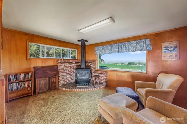This inviting sitting area off the kitchen features a free-standing fireplace, creating a perfect spot to relax and unwind. Enjoy the full-sized window that offers breathtaking views of the valley, making it an ideal place to watch the seasons change and take in the natural beauty....