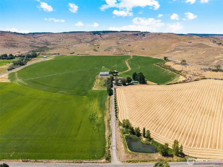 East-facing view from Weaver Road looking up the private driveway, with the pond welcoming you at the front of the property. A picturesque entrance that sets the tone for this expansive ranch—offering privacy, natural beauty, and a true sense of arrival.