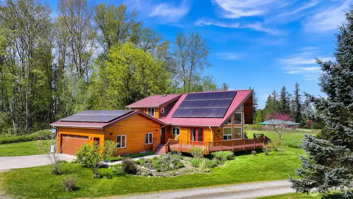 Gorgeous cedar home has metal roof and a large solar array.