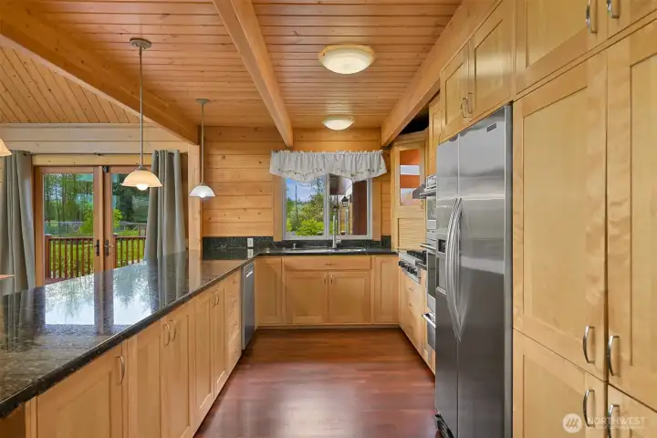 The open kitchen has figured maple cabinets, a Viking cooktop, Bosch dishwasher, and built-in wall oven, convection micro, & warming drawer.
