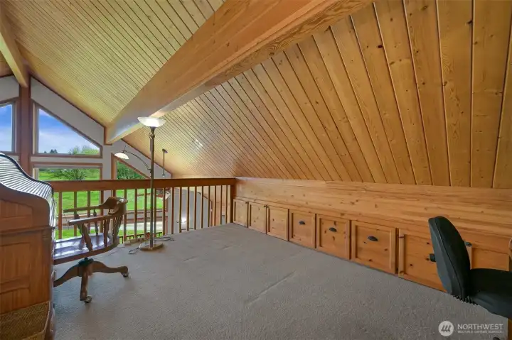 The loft is perfect for a den or office space. Note the built-in drawers and files under the eaves.