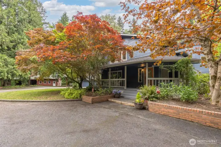 Tucked away on a beautifully landscaped setting with timeless Northwest appeal. Surrounded by mature trees and vibrant Japanese maples, the property features a wraparound porch, circular driveway, and peaceful outdoor spaces perfect for relaxing or entertaining.