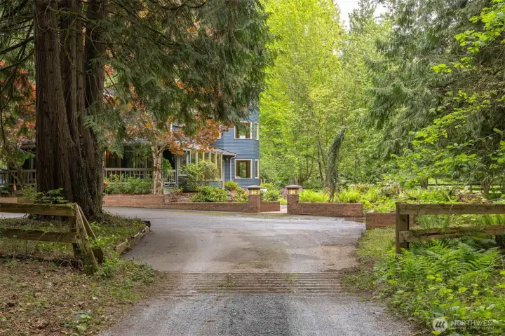 The first glimpse of the home is captivating. Asphalt drive, brick masonry around the perimeter of the home and courtyard.
