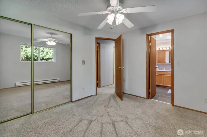 Primary bedroom with ceiling fan and access to the hall bath.