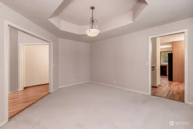 The Bay Window and Coffered Ceiling add so much Character to this Office / Dining Room or  Large Den next to a  Hallway that passes the Dry Bar and into the Kitchen and is also across the hall from the Family Room