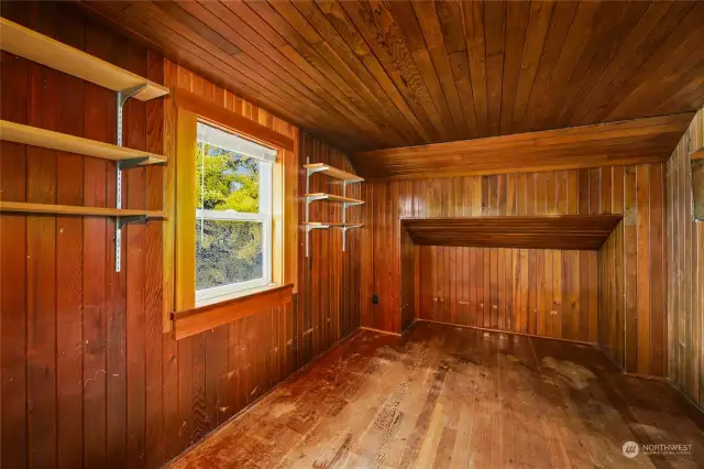 One of two upper bedrooms featuring wood floors, walls, and multiple closets.