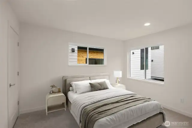 This image is virtually staged. A third generously sized bedroom with dual windows and soft, neutral tones.